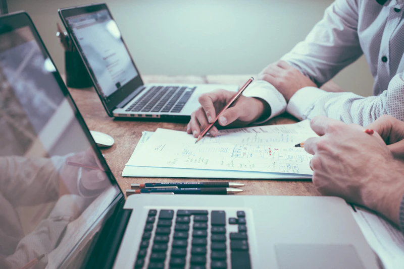 Close-up of a person's hands typing on a laptop, composing a formal letter, with legal documents in the background